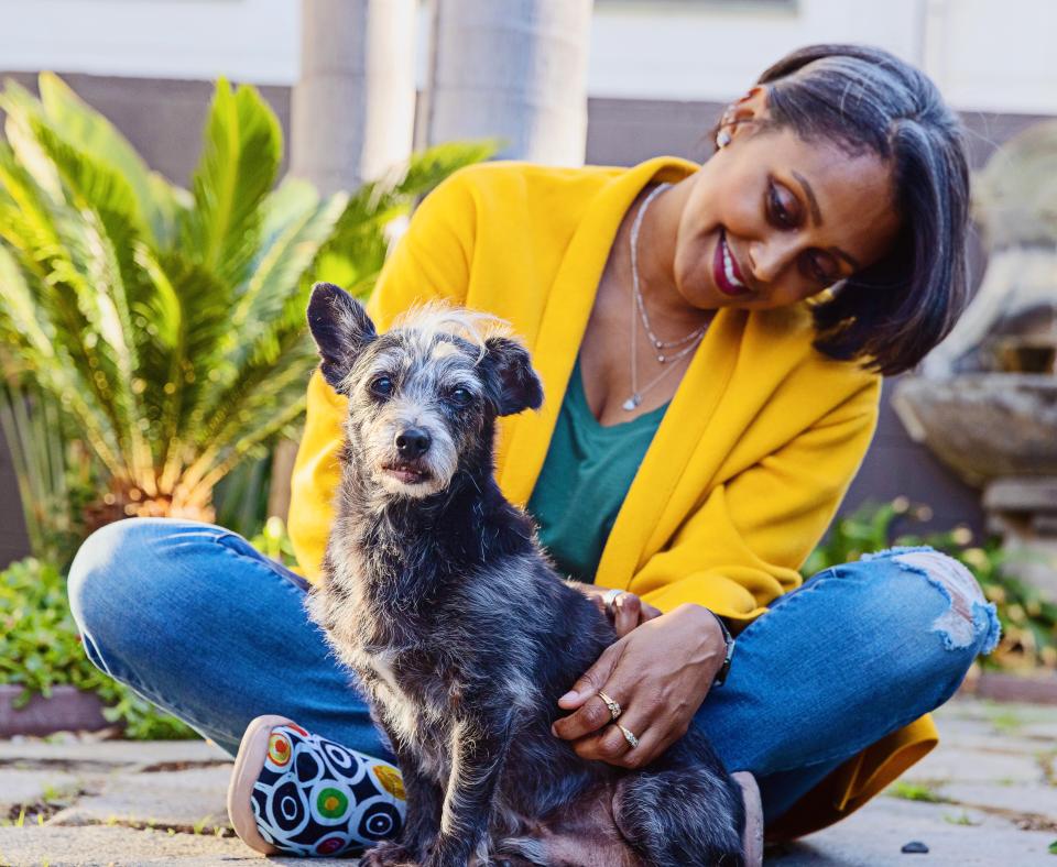 Smiling person sitting with a small dog