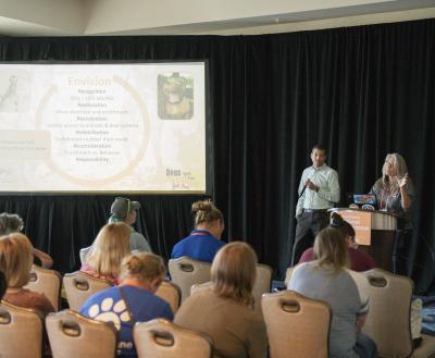 Conference presenters presenting in front of a crowd