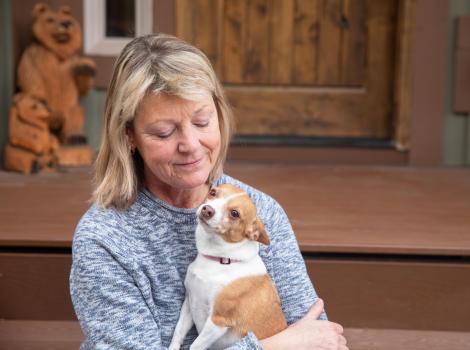 Bonita Vanderkooi holding a small brown and white dog in her arms