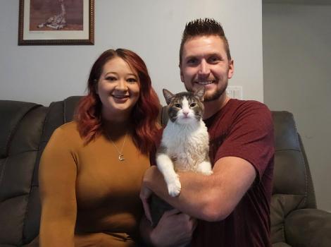 Prancer the cat with her new family on a couch