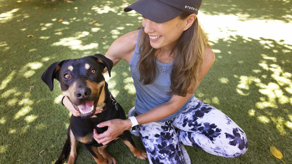 Diana Ross the dog, very happy outside with a person sitting next to her