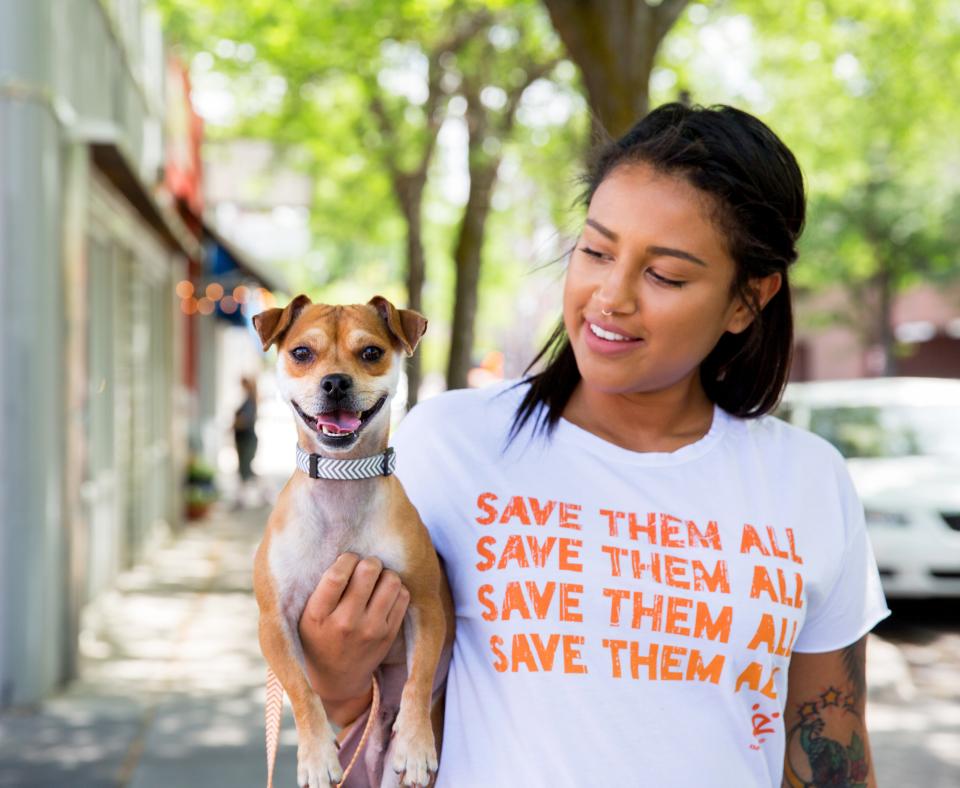 Smiling person looking at a tiny dog that they're holding