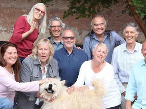 Group shot featuring nine of the co-founders of Best Friends Animal Society with a dog