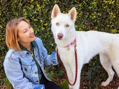 Smiling person sitting outside with a dog