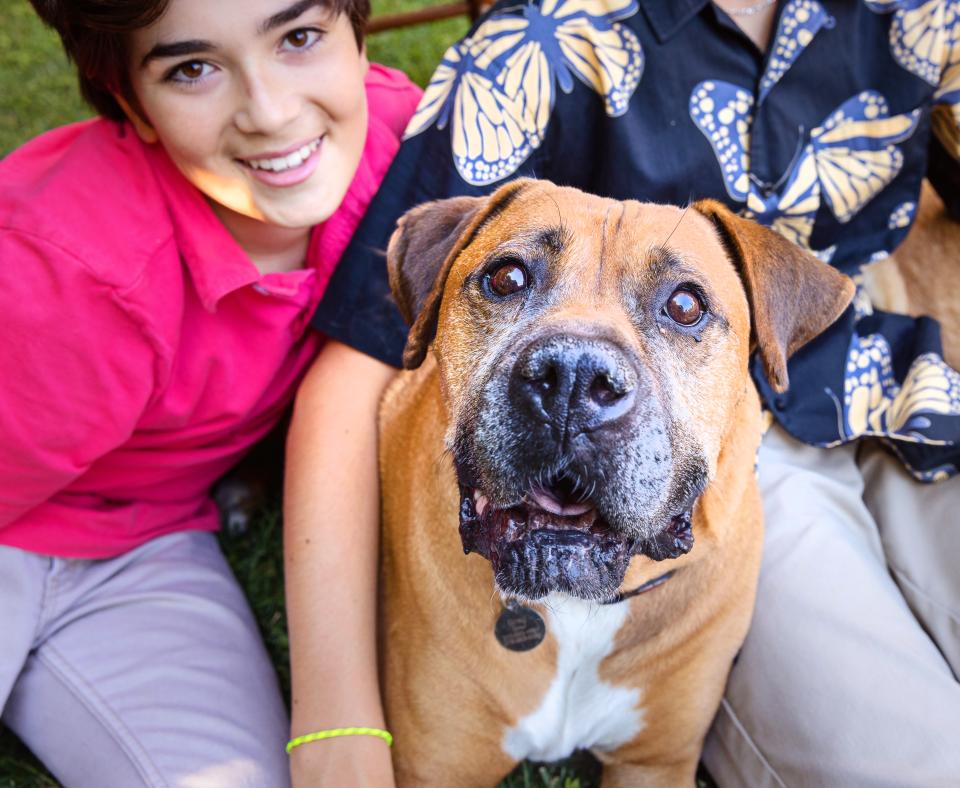 Group of smiling people with a dog outside