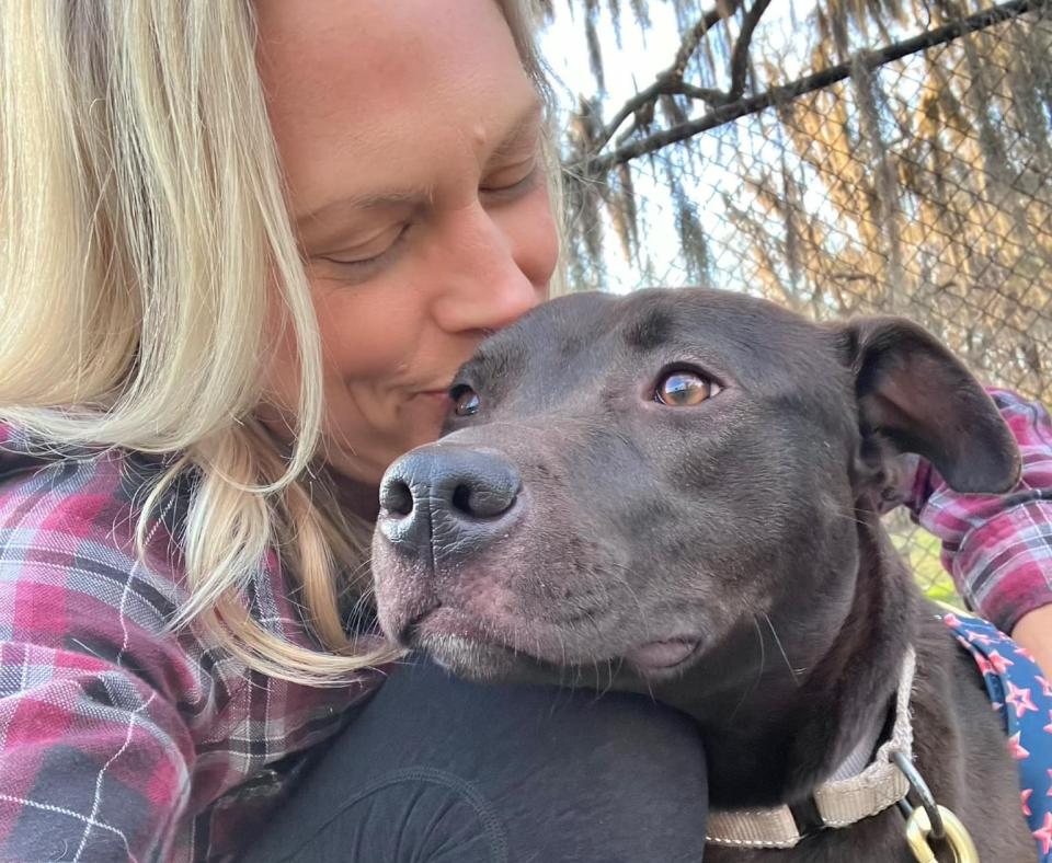 Person kissing the head of Delilah the dog