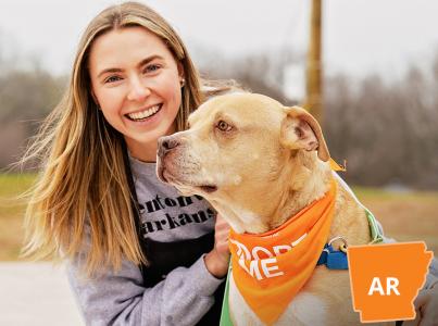 Volunteer sitting with dog outside