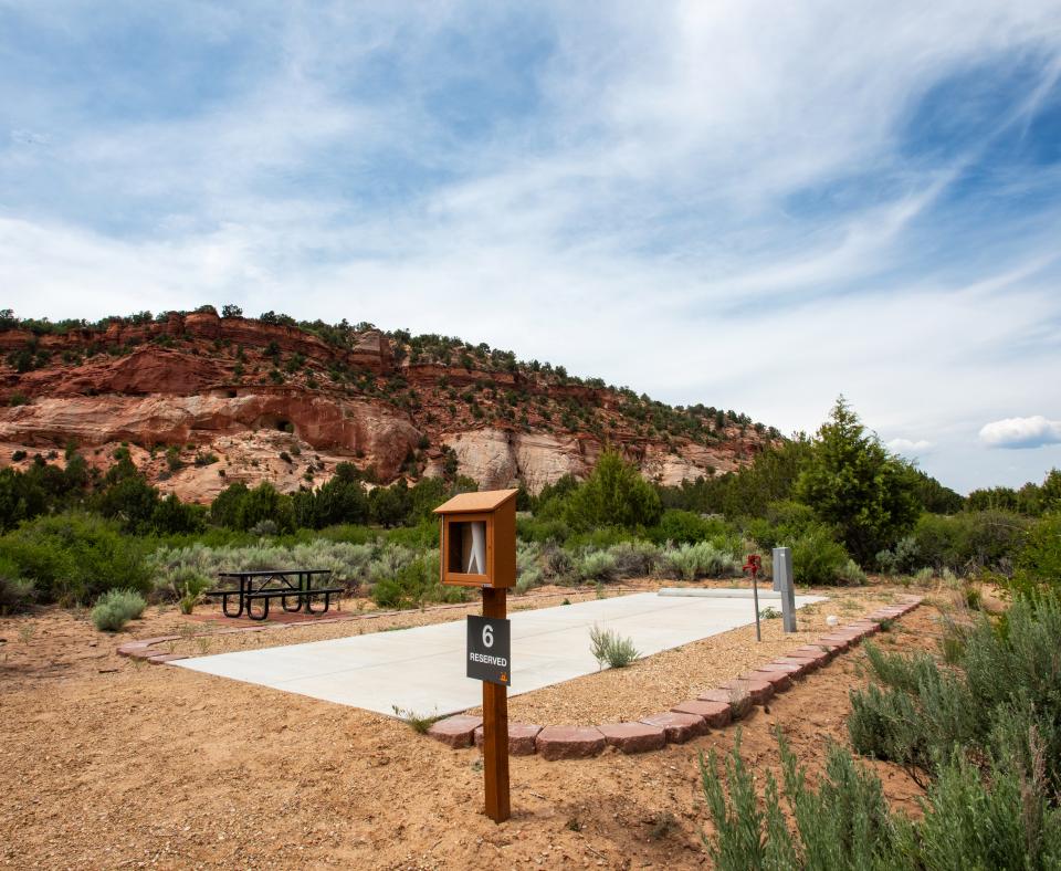 RV site with a backdrop of red rock cliffs and blue sky