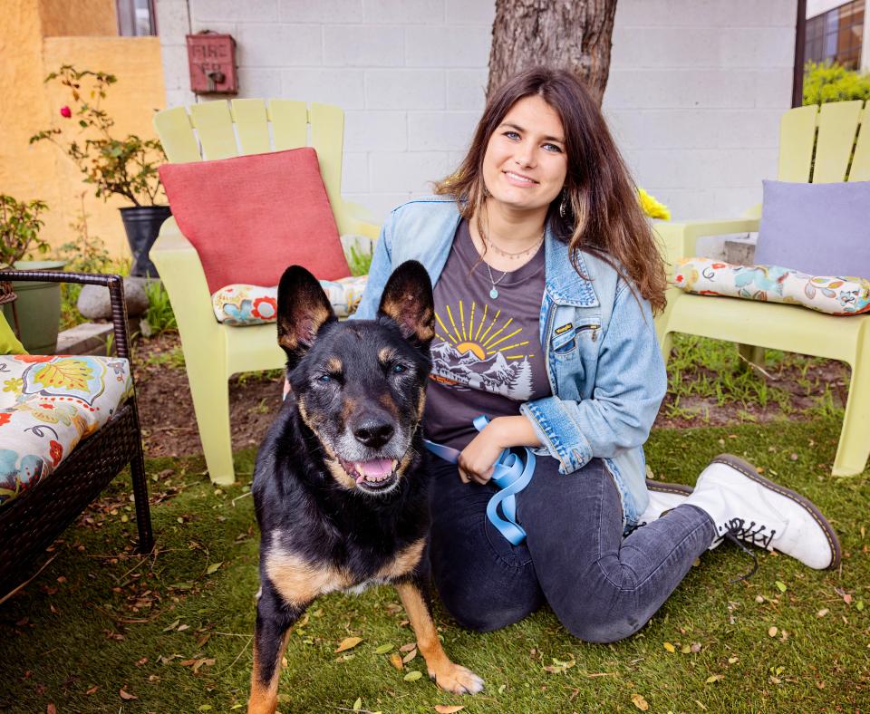 Smiling person relaxing in a yard with a happy dog